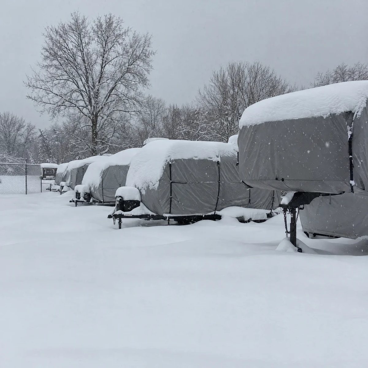 Covered campers in a snowed-in storage lot