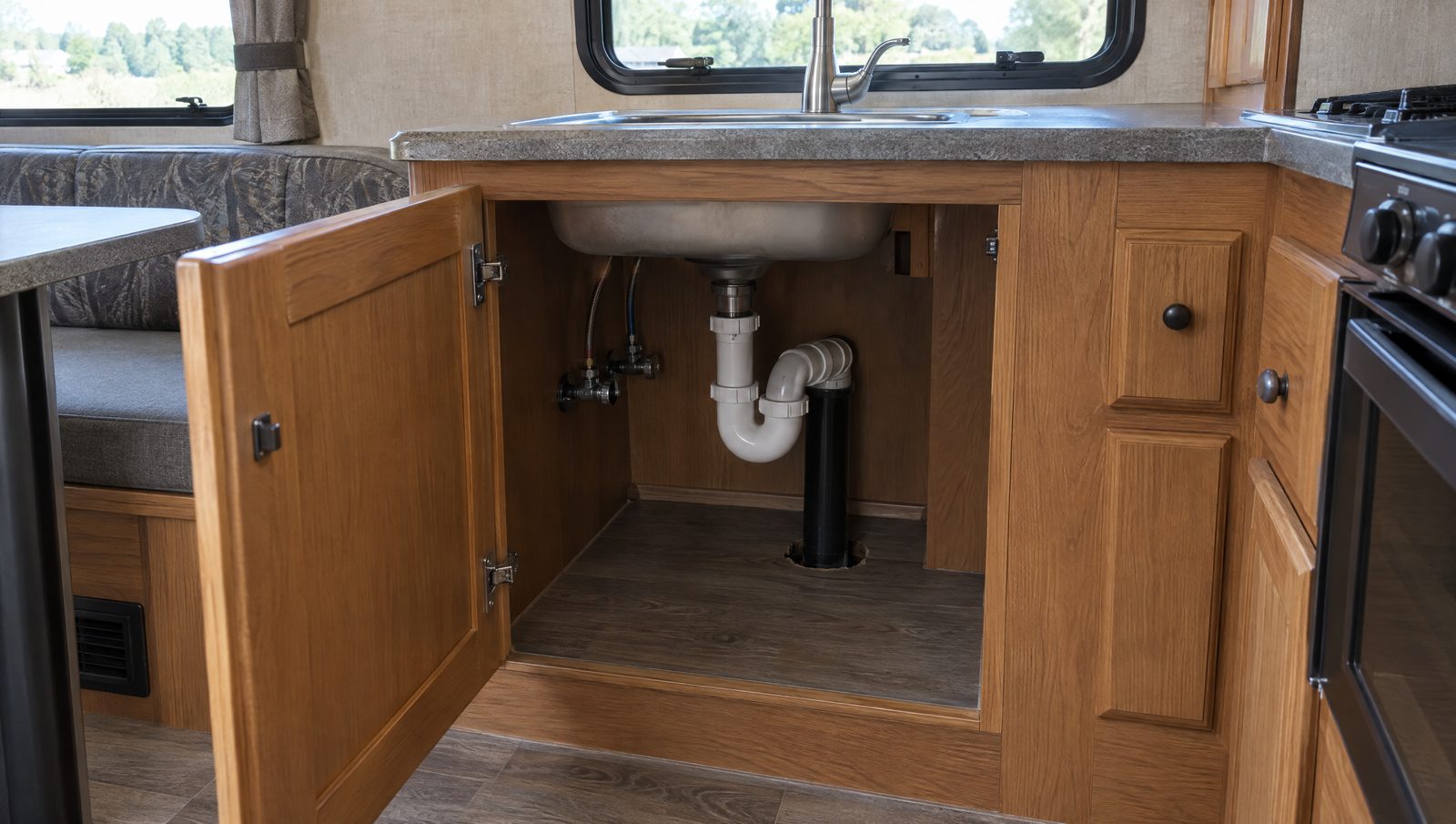 An open cabinet under the sink in a travel trailer